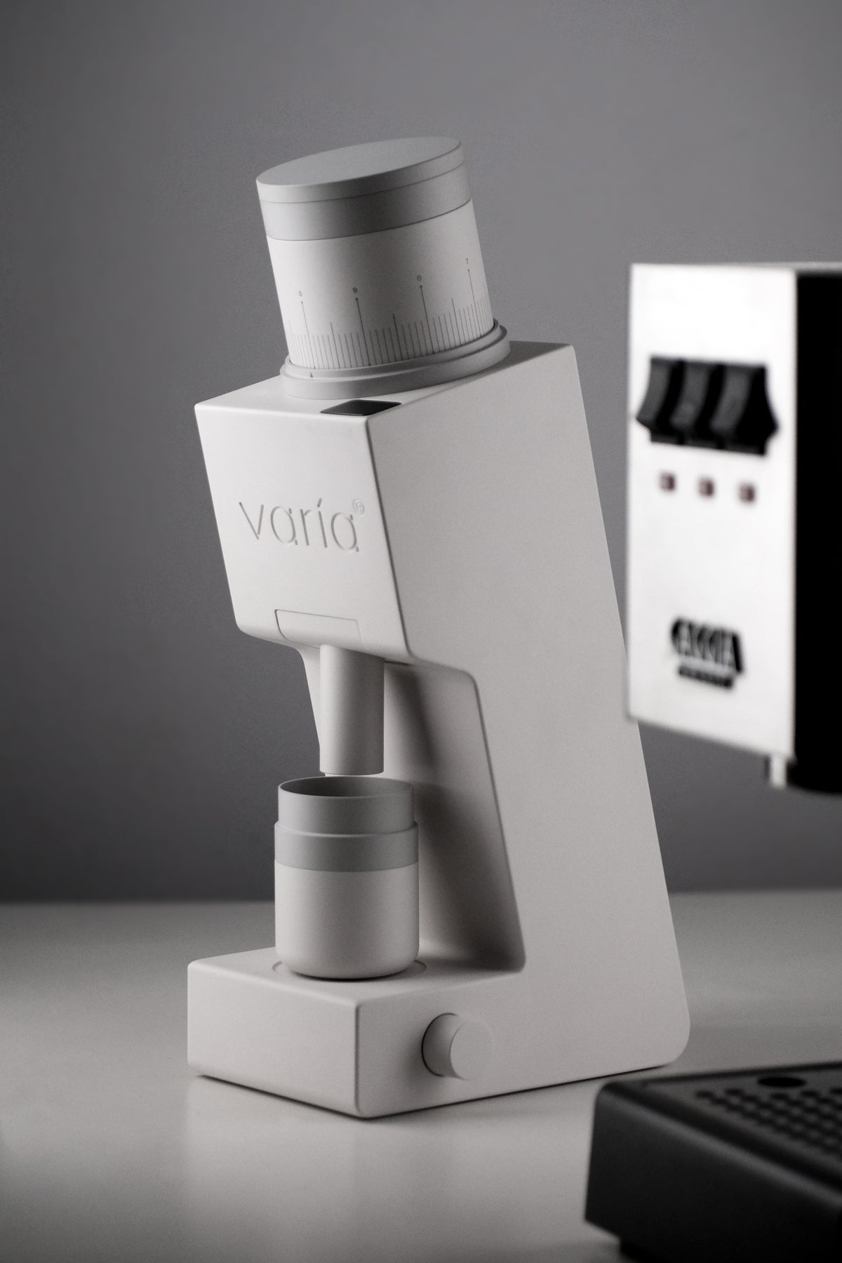 White Varia VS6 beside an espresso machine in a studio coffee setup