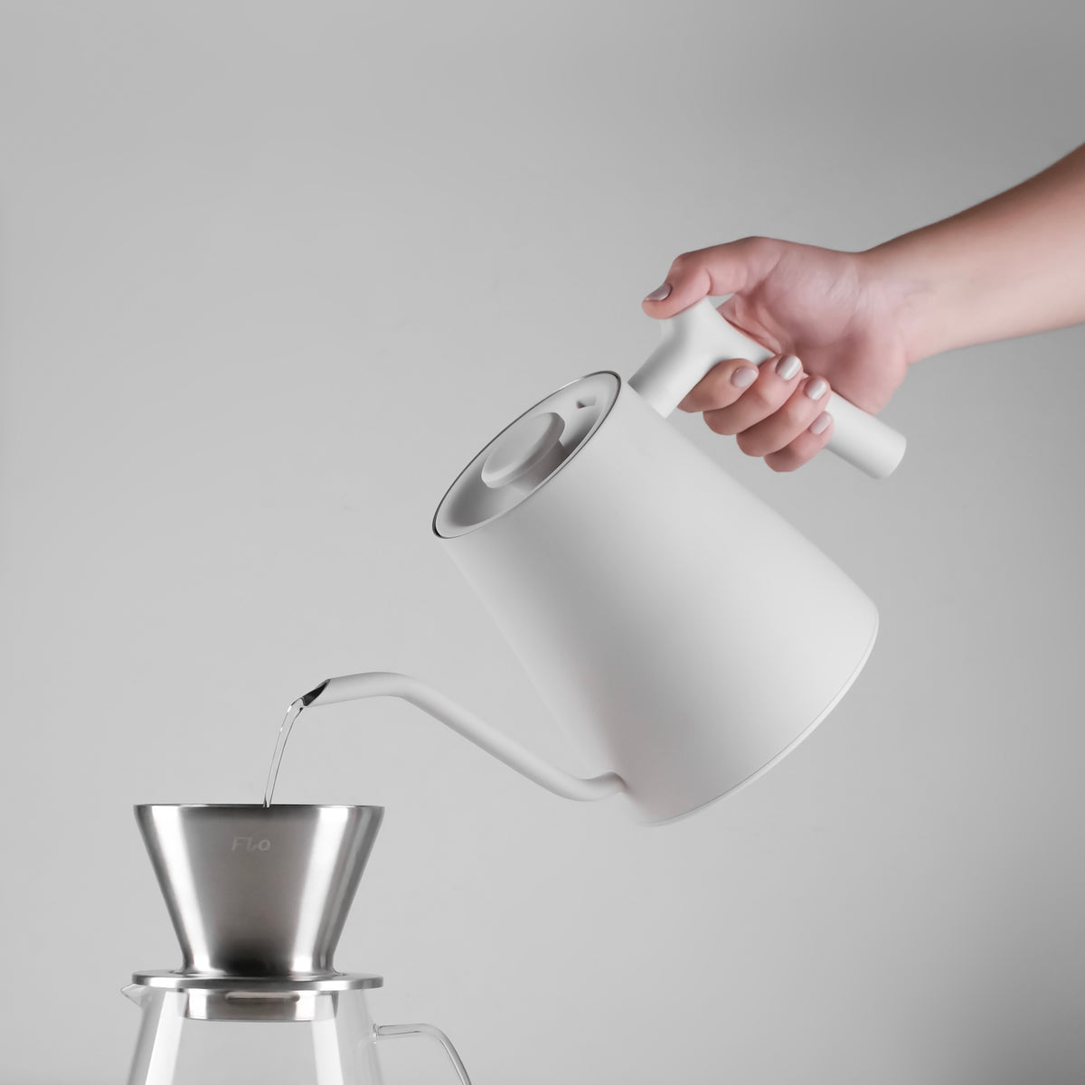 Pouring from the white AURA 0.8 L gooseneck kettle into a FLO dripper