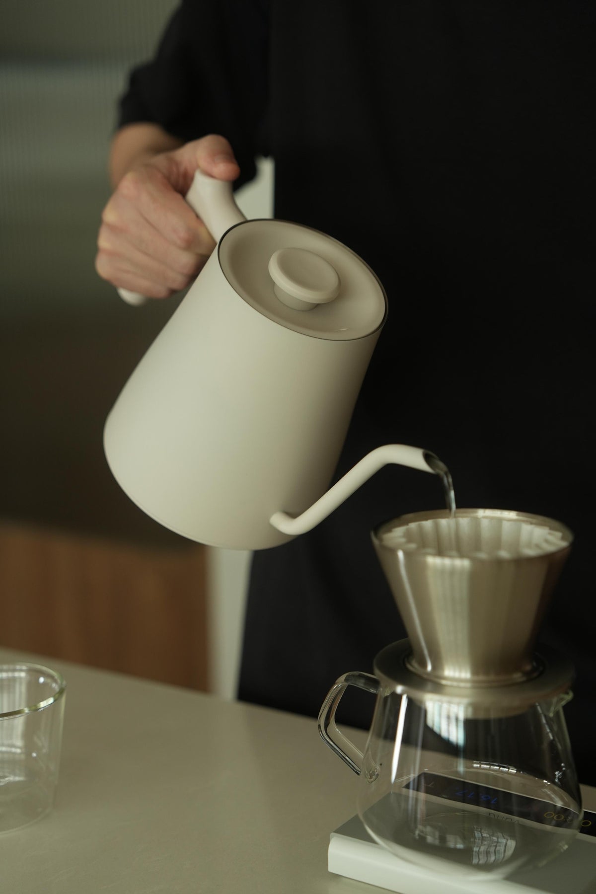 A Varia kettle pouring into a silver FLO dripper at home